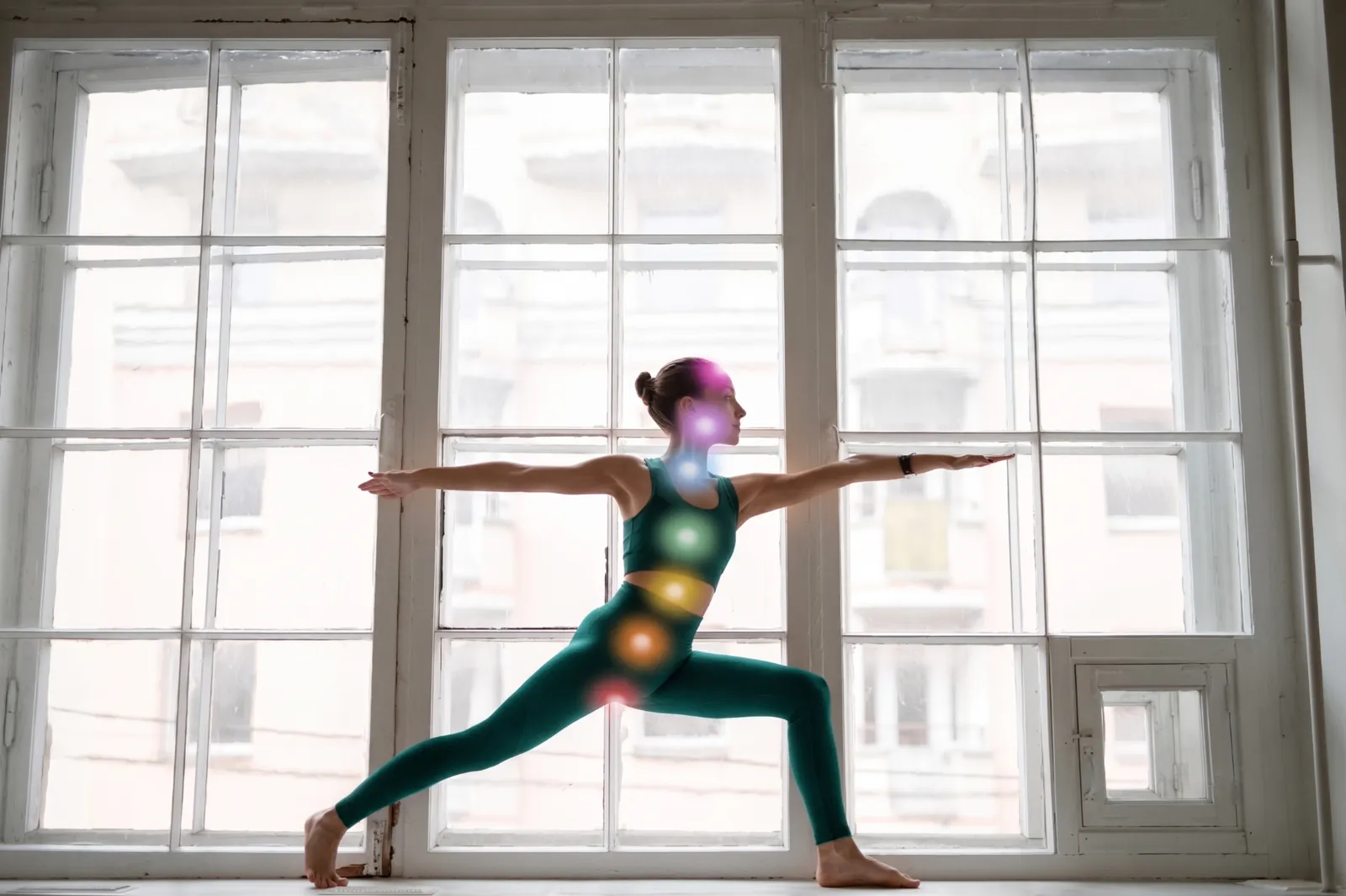 Donna che pratica Pilates davanti a una finestra con punti energetici colorati sovrapposti sul corpo